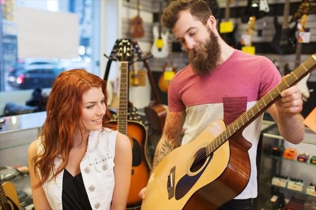 couple of musicians with guitar at music store