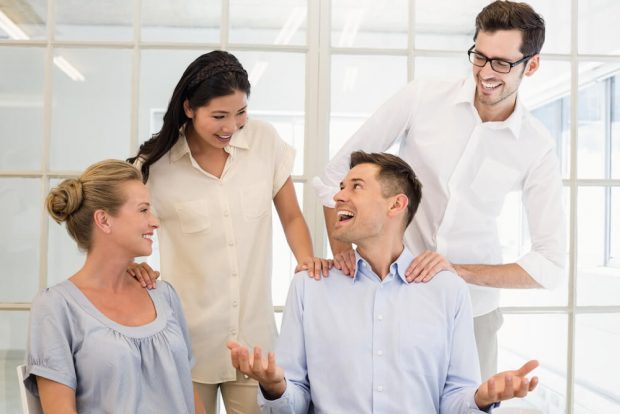 Casual business team congratulating colleague in the office
